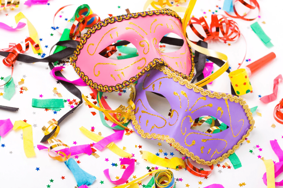 Dos caretas de carnaval entre matasuegras y confeti.