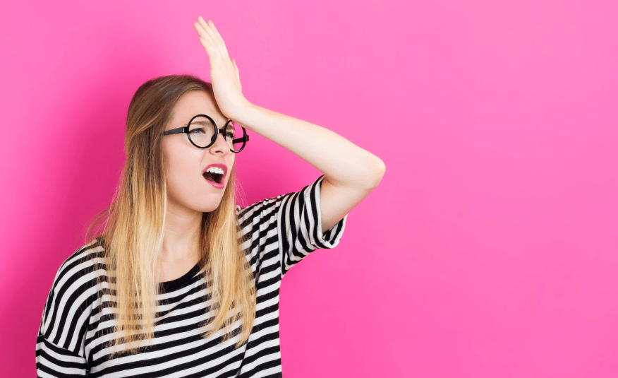 Una joven golpeándose la cabeza en frustración.