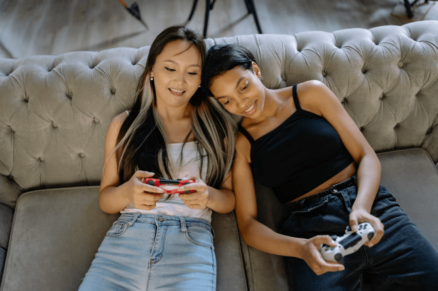 Dos jóvenes con un mando de videojuegos cada una.