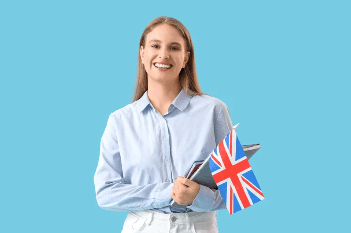 Una joven sujetando la bandera de Reino Unido, y algunos libros.